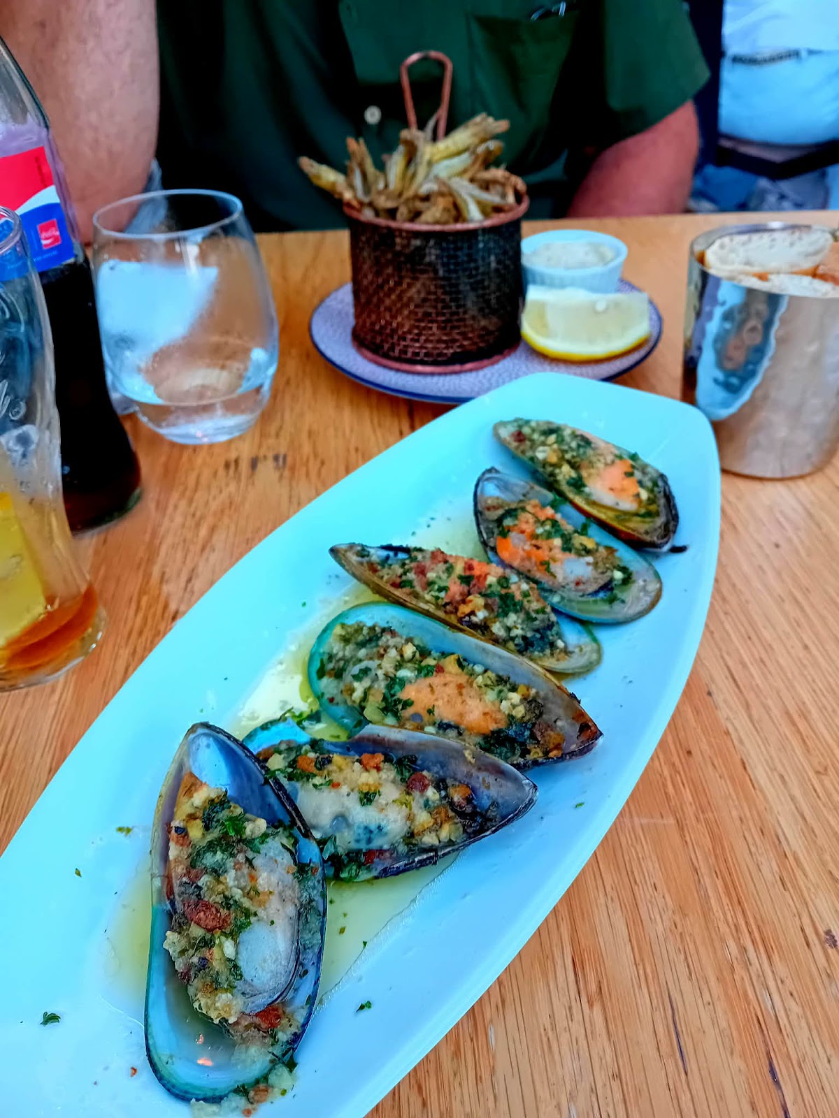 Moules farcies aux herbes et miettes de pain sur assiette blanche