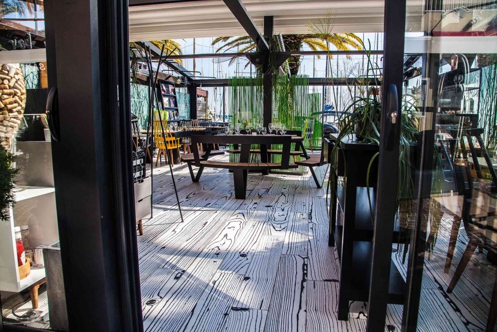 Salle de restaurant moderne avec terrasse intérieure, plantes vertes et mobilier design