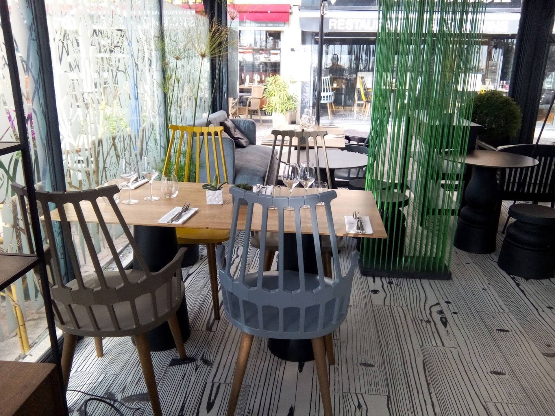 Intérieur moderne de restaurant avec chaises design et cloisons végétales