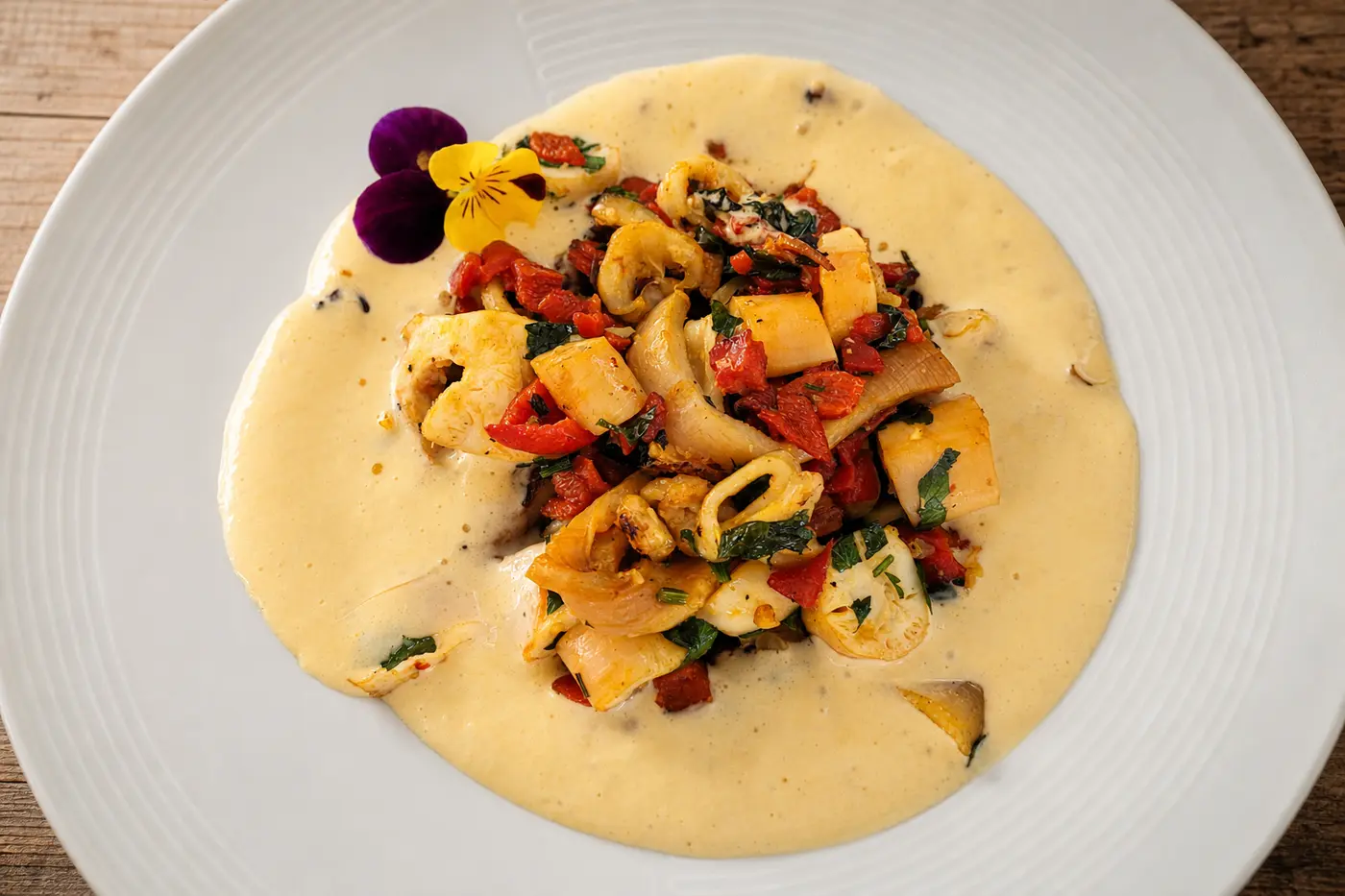 Champignons et légumes poêlés sur crème de safran en assiette gastronomique